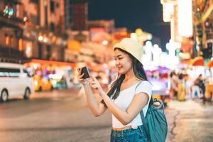 mujer viajera asiática con cámara en el barrio chino. foto