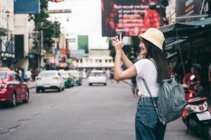 Young asian woman traveling with camera at landmark street market. photo