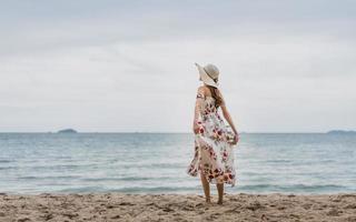 mujer joven relajarse caminando en la playa foto