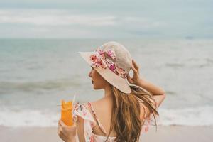 Relax woman drinking refresh orange cocktail on the beach photo