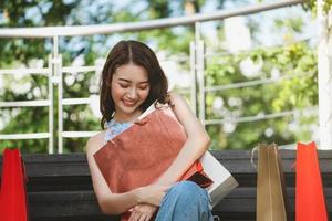 Asian young woman hug shopping bags photo