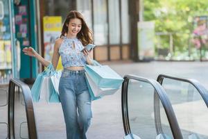 Asia young woman use mobilephone when shopping