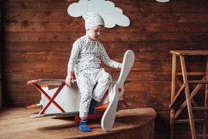 niño jugando con avión de madera foto