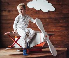 kid playing with wooden airplane photo