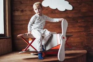 kid playing with wooden airplane photo