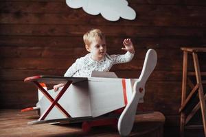 kid playing with wooden airplane photo