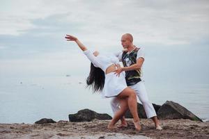 pareja amorosa bailando en la playa del mar en verano foto