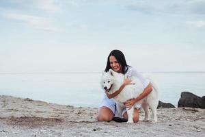 woman playing with her dog on the beach photo