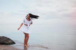 woman in a white shirt and skirt dancing barefoot photo