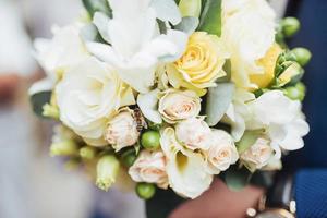 wedding bouquet in hands of the groom photo