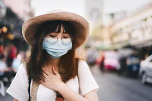 Young asian traveller use mask for protect virus has sneezing. photo