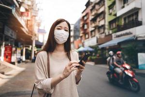 empresaria joven asiática soltera usa mascarilla para proteger el virus de la corona o covid 19 foto