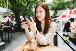 Relax asian woman at cafe using smart phone for social media. photo