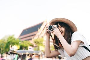 Young asian cute woman traveling in Bangkok and take photo with camera.