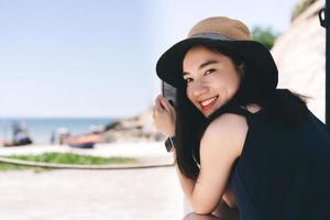 retrato de una joven asiática adulta que se relaja en el café de la playa con un estilo de vida moderno