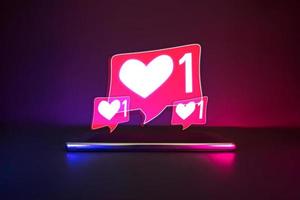 Smartphone with love social symbol neon logo. Blue and pink light background. photo