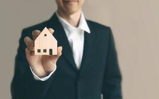 Business realtor man holding home model for investment photo