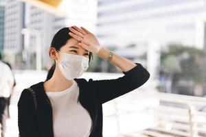 mujer trabajadora asiática de negocios adulta usa mascarilla enferma con la pandemia del virus de la corona foto