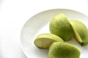 Green apple slices on a white plate photo