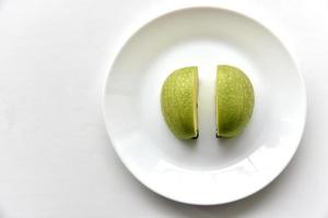 Green apple slices on a white plate photo