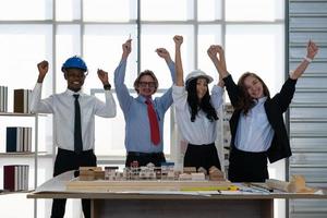 el equipo de arquitectos e ingenieros celebra el éxito del trabajo en el cargo foto