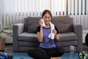 mujeres asiáticas limpiándose el sudor después de hacer ejercicio en casa. foto