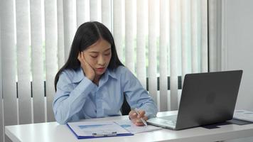 las mujeres asiáticas están aburridas de trabajar en la oficina.