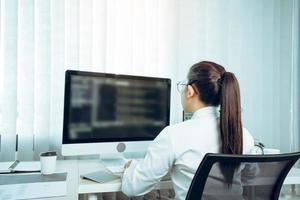 Software developers are analyzing about the code written into the program on the computer in office room. photo