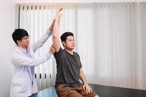 quiropráctico estirando el brazo de un joven en el consultorio médico