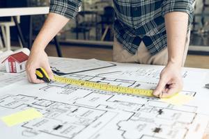 Architects are working on a new project while using a tape measure. photo