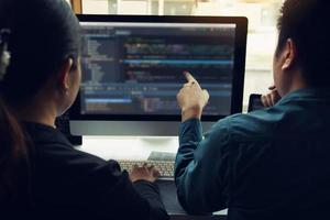 dos desarrolladores de software están analizando juntos el código escrito en el programa en la computadora. foto
