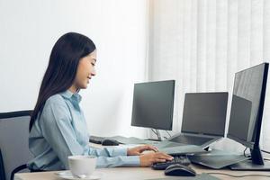 Asian young female programmer working developer programing on a computer code at office. photo