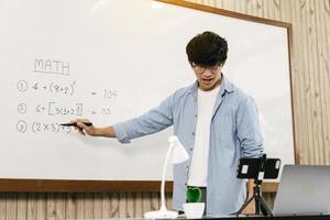 Teacher explaining the numbers on the board while video calling with students studying online. photo