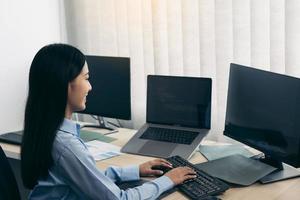 Asian young female programmer working developer programing on a computer code at office. photo