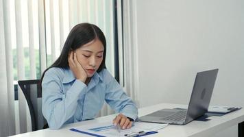 las mujeres asiáticas están aburridas de trabajar en la oficina.