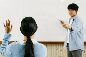 Asian male teacher teaching students at the classroom photo