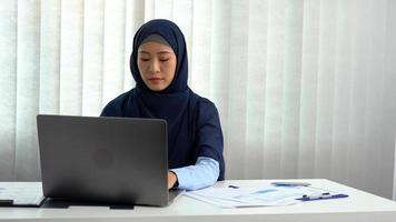 Muslim woman sitting happily at the office. photo