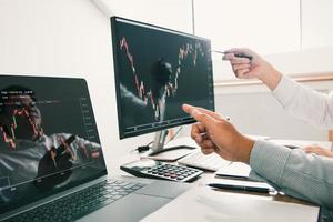 Two business stock brokers stress and looking at monitors displaying financial stock graph report information. photo