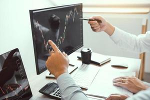 Investors are pointing to laptops that have investment information stock markets and partners taking notes and analyzing performance data. photo