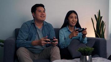 Asian couples are having fun playing games in their living room at night. photo