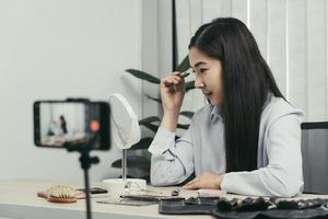 la joven bloguera de belleza asiática está exhibiendo productos cosméticos, así como tutoriales sobre cómo aplicar y grabar tutoriales de maquillaje en las redes sociales. foto