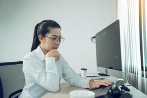 Asian female software developer is worried about analyzing code-based systems at his office. photo