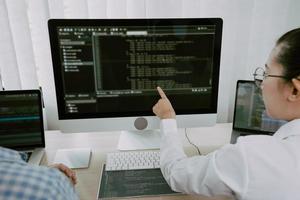 dos equipos asiáticos que trabajan en el desarrollo de programadores de diseño de sitios web de tecnología de programación y encriptación en el escritorio de la oficina. foto