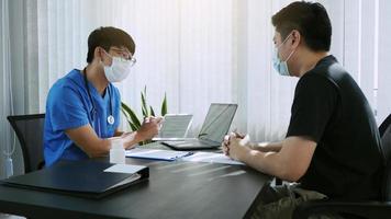 Doctors are explaining the treatment of a sick patient in tablets while wearing a mask during the virus outbreak. photo