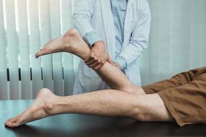 los fisioterapeutas usan sus manos para revisar los músculos de la pantorrilla.