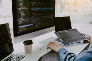 Asian man working code program developer computer web development working design software on desk in office. photo