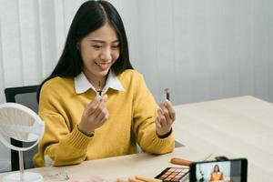 Young Asian beauty blogger is showcasing cosmetic products as well as tutorials on how to apply and record makeup tutorials on social media networks. photo