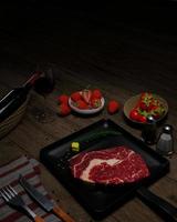 Fresh beef for steaks With olive oil on top Place on a Teflon pan. Seasoning of white pepper and black pepper, decorated with cherry tomatoes. Black Marble Table There is a knife and fork.3D Rendering photo