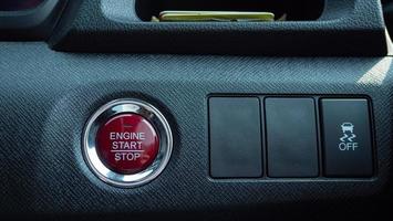 A red button for start the engine of the car. Modern vehicles use a remote key and a single push button to start the engine or turn off the engine electrically. photo