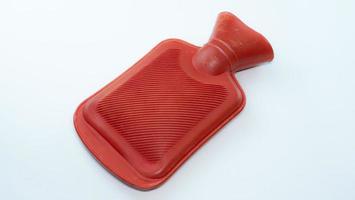 Red hot water bag for compressing Relieve muscle injuries or keep warm. Place it on a white background. A device for holding hot water. To compress before physical therapy. photo